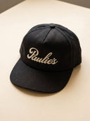 Paulie's Original Cap in black with the cream embroidered Paulie's script